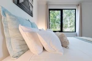 a bedroom with white pillows on a bed with a window at Hadspen Riverview Retreat: 2 Bedroom Unit in Hadspen