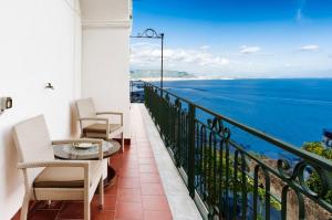 balcón con mesa, sillas y vistas al océano en Residence Mareluna - Amalfi Coast, en Vietri