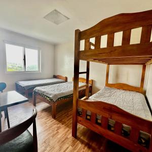 a bedroom with two bunk beds and a table at Baguio BELL Staycation in Baguio