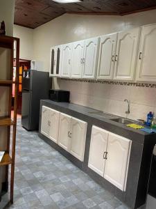 uma cozinha com armários brancos e um frigorífico preto em Casa de Lujo 5 estrellas ! em Iquitos