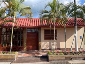 une maison avec des palmiers devant elle dans l'établissement Casa de Lujo 5 estrellas !, à Iquitos