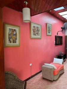 a red wall with a table and a chair in a room at Casa de Lujo 5 estrellas ! in Iquitos