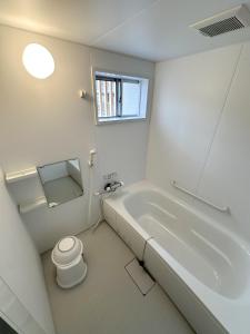 a white bathroom with a tub and a toilet at Hotel Rakusai in Kyoto
