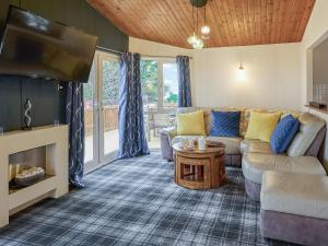 a living room with a couch and a flat screen tv at Cabin Retreat in Skelmorlie