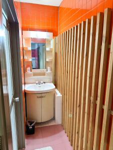 a bathroom with a sink and an orange wall at Hotel Rakusai in Kyoto +22 photos