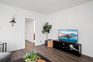 een woonkamer met een flatscreen-tv aan een witte muur bij Southern Oregon Gem in Medford