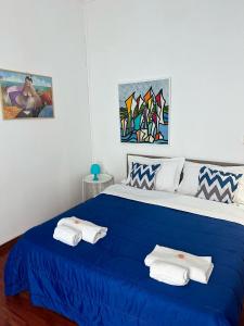 Un dormitorio con una cama azul con toallas. en Via Zara en Palermo