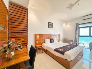 1 dormitorio con cama, escritorio y mesa en DA NANG BAY HOTEL, en Da Nang