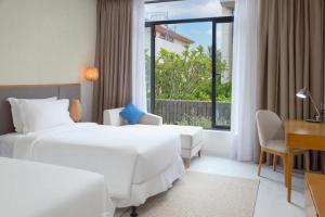 une chambre d'hôtel avec deux lits, un bureau et une fenêtre dans l'établissement Apartment in Wyndham Garden Cam Ranh, à Nha Trang