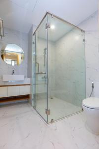 y baño con ducha de cristal y aseo. en TMS Beachfront Quy Nhon Apartment en Quy Nhon