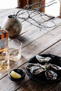 a table with a plate of oysters on a table at SABI Award Winning Designer Cabin in Binalong Bay +25 photos