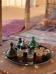 a tray with a plate of food and drinks on a table at Bivouac Erg Chegaga Nomademoi in El Gouera