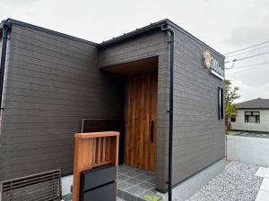 una pequeña casa negra con puerta de madera en 360stay - Vacation STAY 18091v en Hagi