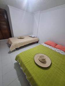 a room with a bed with a hat on it at Apartamento El Rosal in Ibagué