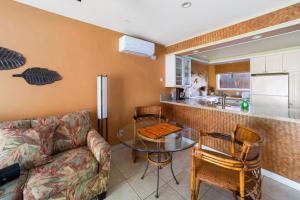 a living room with a couch and a table and a kitchen at Gardenia Suite located across from beach in a boutique property in Kihei