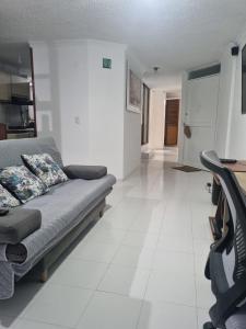 a living room with a couch and a white tile floor at Apartamento El Rosal in Ibagué