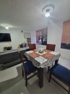 a dining room with a table and two chairs at Apartamento El Rosal in Ibagué