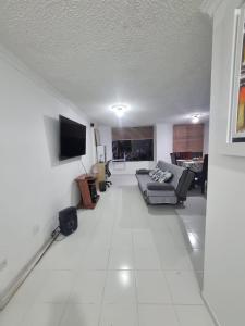 a living room with a couch and a flat screen tv at Apartamento El Rosal in Ibagué