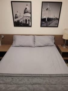 een slaapkamer met een wit bed met twee foto's aan de muur bij Apartamento Flat em Boa Viagem in Recife +20 foto's