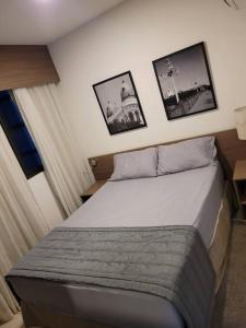 een bed in een slaapkamer met foto's aan de muur bij Apartamento Flat em Boa Viagem in Recife