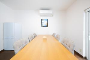 a conference room with a long wooden table and chairs at Kirin House in Furano