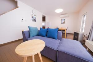 a living room with a blue couch and a table at Kirin House in Furano