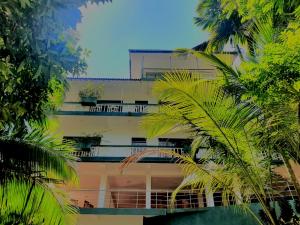 un edificio alto con palmeras delante en Rainforest Lodge, Deniyaya, en Deniyaya