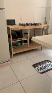 una mesa de madera en una cocina junto a una nevera en Ap proximo ao Aeroporto e ao Shopping Pátio Maceió en Maceió