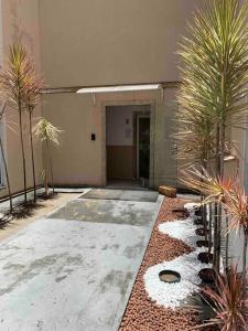 a building with a courtyard with palm trees and gravel at Ap proximo ao Aeroporto e ao Shopping Pátio Maceió in Maceió