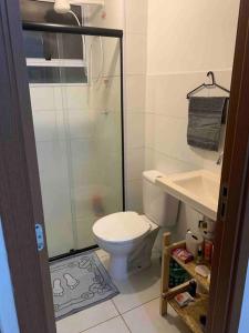 a bathroom with a toilet and a glass shower at Ap proximo ao Aeroporto e ao Shopping Pátio Maceió in Maceió