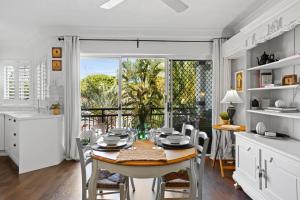 una cucina e una sala da pranzo con tavolo e sedie di Coastal 1-Bed Apartment with Pool & Tennis Court a Gold Coast