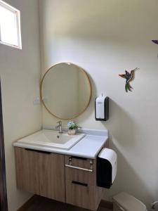 ein Bad mit einem Waschbecken und einem Spiegel in der Unterkunft Casa del Sol, Barra de Santiago in Barra de Santiago