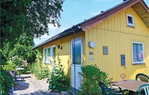 a yellow house with a picnic table in front of it at Awesome Home In Svendborg With Kitchen in Thurø By