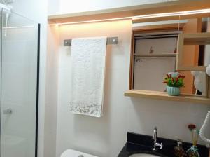 a bathroom with a shower and a sink and a mirror at Studio Luxo, em Anápolis - Perfeito in Anápolis +30 photos