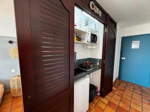 kuchnia z drzwiami prowadzącymi do kuchni ze zlewem w obiekcie La Caravelle - Agréable studio vue sur mer avec piscine w mieście La Trinité