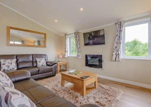 a living room with a couch and a table at Woodhall Country Park Lodges in Woodhall Spa