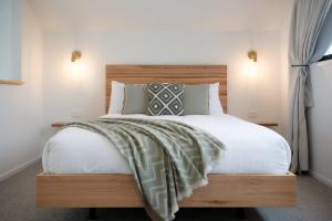 a bedroom with a large bed with a wooden headboard at Koze Haus - Blissful Barn by the River in Hillwood