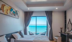 1 dormitorio con cama y vistas al océano en TMS Beachfront Quy Nhon Apartment en Quy Nhon