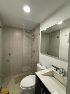 uma casa de banho com um WC, um lavatório e um espelho. em Rústico 804 Lago Sochagota em Paipa