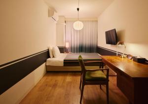 a bedroom with a bed and a desk and a chair at Hotel Graphy Nezu in Tokyo