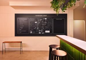 a bar with two stools in front of a wall at Hotel Graphy Nezu in Tokyo