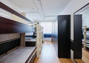 a dorm room with bunk beds and a hallway at Hotel Graphy Nezu in Tokyo