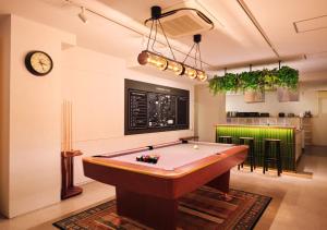 a billiard room with a pool table and a clock at Hotel Graphy Nezu in Tokyo