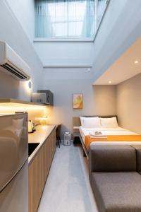 um pequeno quarto com uma cama e uma cozinha em NEWLY REFURBISHED - Heritage Collection on Ann Siang em Singapura