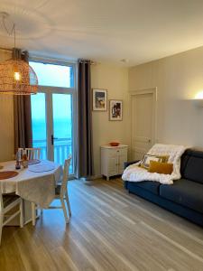 a bedroom with a bed and a table and a dining room at Appartement ROCK WILL in Dinard