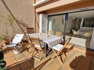 um pátio com uma mesa e cadeiras numa varanda em Appartement Sainte-Maxime, 4 pièces, 6 personnes - FR-1-780-25 em Sainte-Maxime
