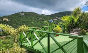 una terraza verde con vistas a la montaña en OCEAN VIEW VILLA, Tortola, British Virgin Islands, en Tortola Island