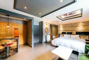 a bedroom with a large bed and a dining room at Hotel Ssome Jeongkwan in Busan