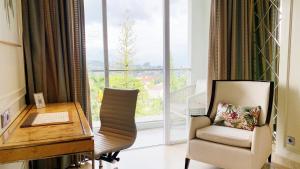 a room with a desk and a chair and a window at Art Deco Luxury Hotel & Residence in Bandung