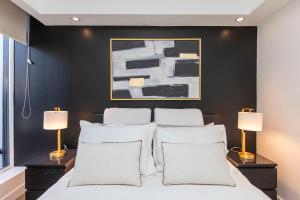a bedroom with a black accent wall and a bed with white pillows at Westview Luxury Suites in Ottawa